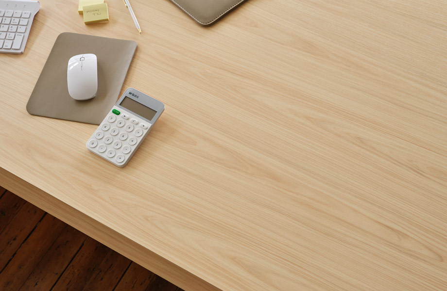 Calculatrice, clavier et souris sur un bureau de travail en stratifié de marque Formica Hickory Naturel Raffiné 
